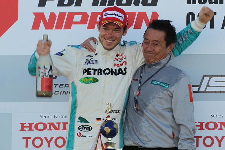 表彰台で歓喜のアンドレ・ロッテラーとトムスチームの館信秀監督