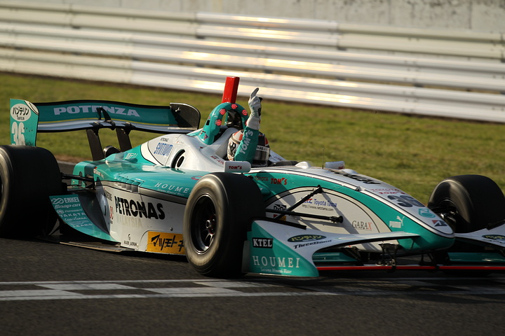 優勝してコントロールラインを横切りガッツポーズのアンドレ・ロッテラー（トムス）