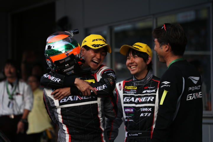 決勝レース: GT300クラスで優勝し抱き合うアンドレ・クートと千代勝正、そして富田竜一郎