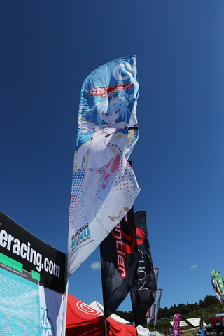 ピットウォーク: 晴れ渡った空にグッドスマイルののぼりがはためく