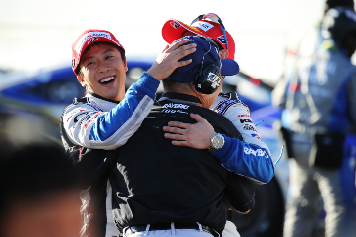 決勝レース: GT500クラスで優勝し抱き合う伊沢拓也・山本尚貴・高橋国光監督（TEAM KUNIMITSU）