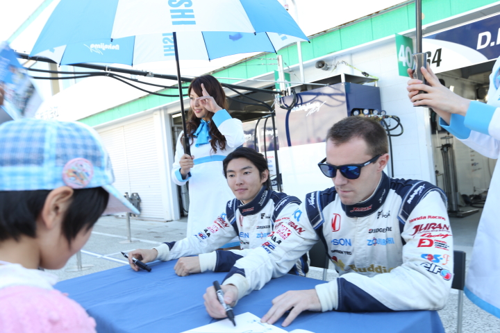 ピットウォーク: サインをする中嶋大祐（奥）とベルトラン・バゲット（手前）