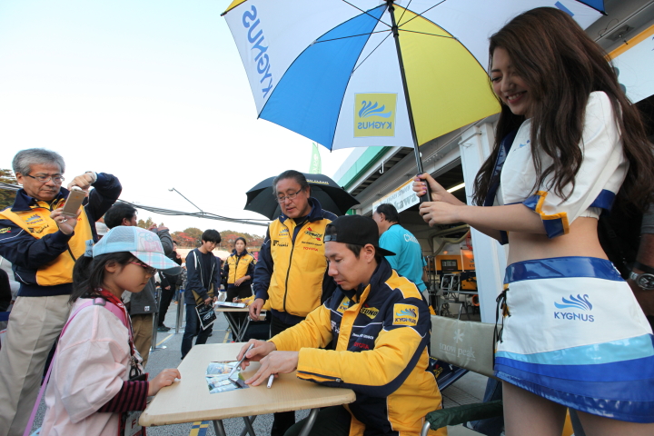 キッズピットウォーク: サインをする小林可夢偉（KYGNUS SUNOCO Team LeMans）