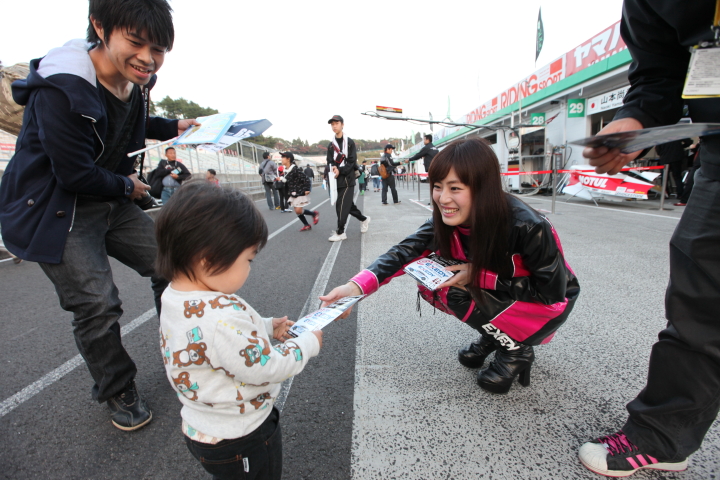 キッズピットウォーク: 子どもにグッズを手渡すチームスタッフ