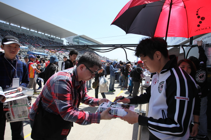 ピットウォーク: サインをする塚越広大（REAL SF14）