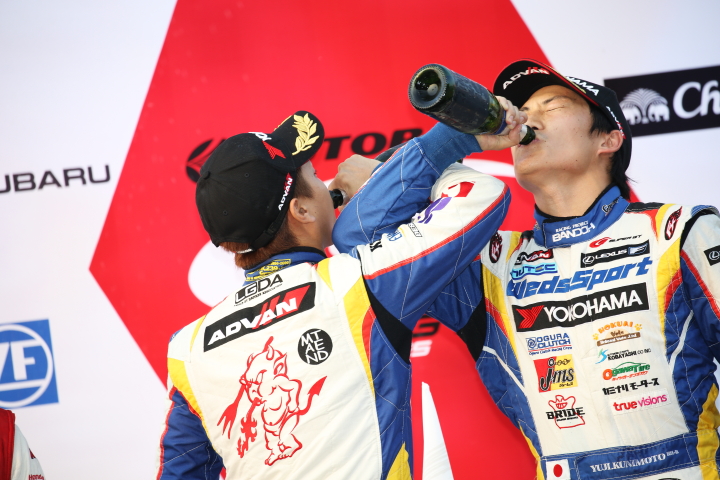 表彰式: シャンパンを飲むGT500クラス優勝の関口雄飛と国本雄資（LEXUS TEAM WedsSport BANDOH）