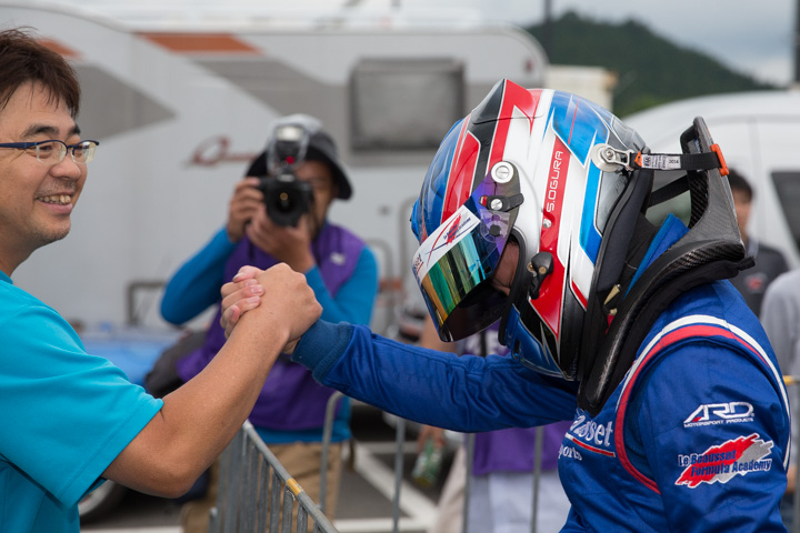 優勝した小倉祥太（右）と握手する坪松唯夫監督（左）