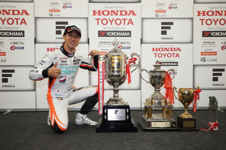 シリーズ表彰式: トロフィーの横でガッツポーズの石浦宏明（P.MU/CERUMO · INGING）