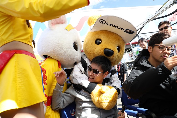 ピットウォーク: くま吉に羽交い締めにされる小林崇志（TEAM UPGARAGE）