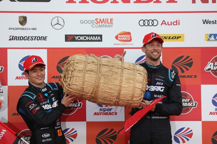 表彰式: GT500クラスでチャンピオンを決め米1俵を受け取る山本尚貴とジェンソン・バトン（TEAM KUNIMITSU）