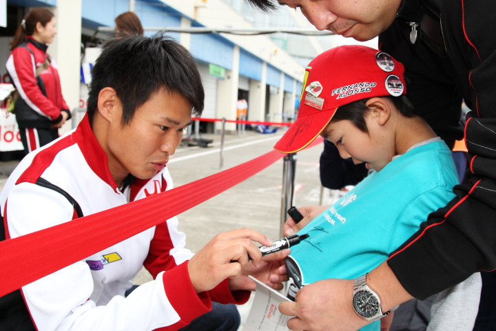 子供にサインする塚越広大（DOCOMO TEAM DANDELION RACING）
