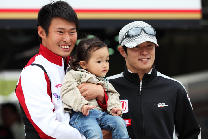子供を抱く塚越広大（DOCOMO TEAM DANDELION RACING）と山本尚貴（TEAM無限）