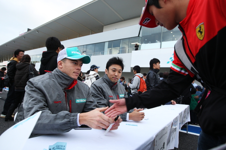 サインするアンドレ・ロッテラーと中嶋一貴のトムスコンビ