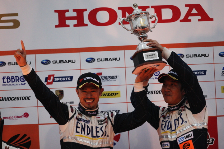 GT300クラス表彰式: 優勝した峰尾恭輔と横溝直輝（エンドレス TAISAN 911）