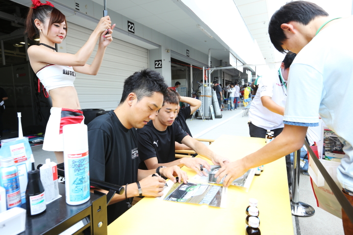 ピットウォーク: サインをする藤井誠暢と佐々木大樹（GT3:スリーボンド 日産自動車大学校）