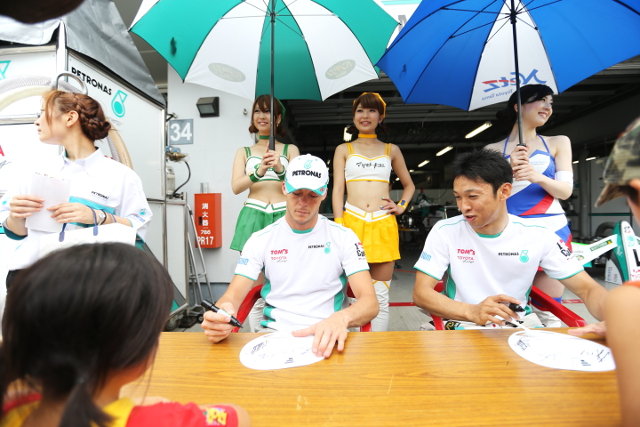 サインするアンドレ・ロッテラーと中嶋一貴（PETRONAS TEAM TOM’S）