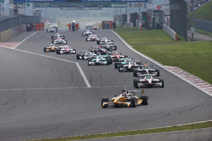 フォーメーションラップで1コーナーになだれ込むマシンたち