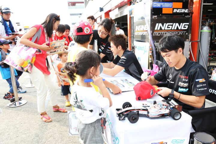 キッズピットウォーク: サインする国本雄資と平手晃平（P.MU/CERUMO·INGING）