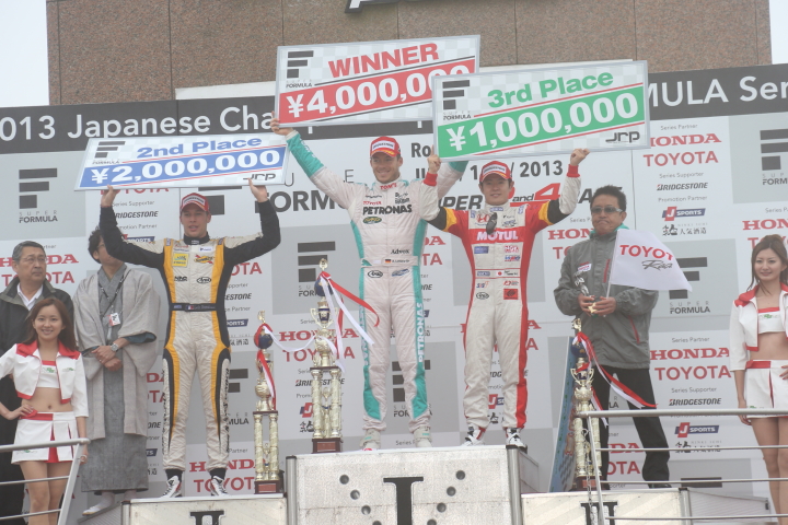 表彰式で賞金ボードを掲げるドライバーたち