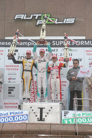 表彰式でトロフィーを掲げるドライバーたち