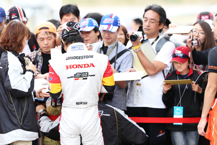 ピットウォーク: サインをする佐藤琢磨（TEAM 無限）