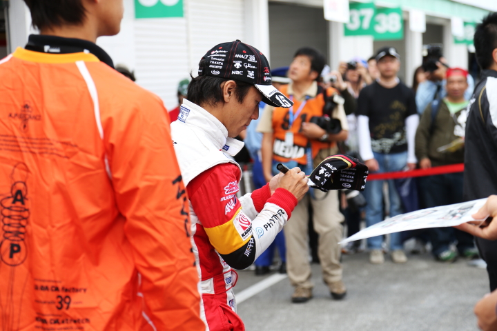 ピットウォーク: サインをする佐藤琢磨（TEAM 無限）