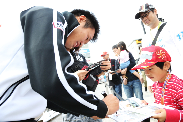 ピットウォーク: サインをする塚越広大（HP REAL RACING）