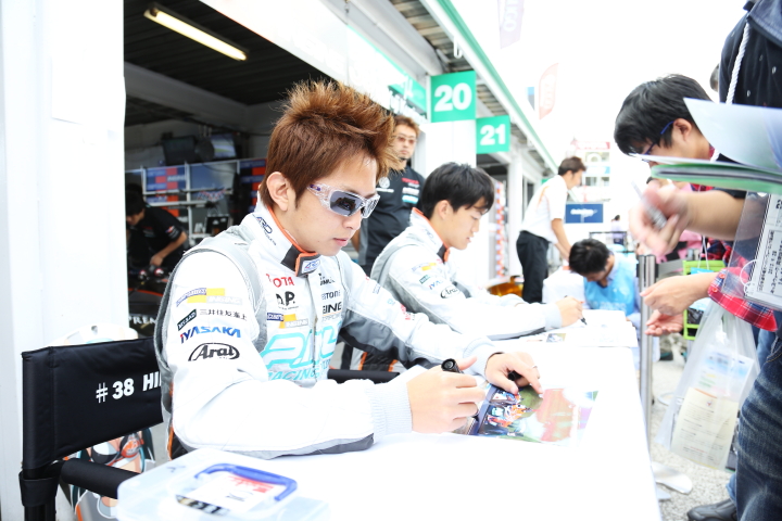 ピットウォーク: サインをする平手晃平と国本雄資（P.MU/CERUMO·INGING）