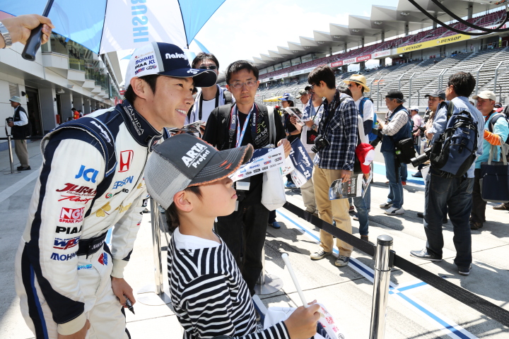 ピットウォーク: ファンの子供と並んで笑顔の中嶋大祐（NAKAJIMA RACING SF14）