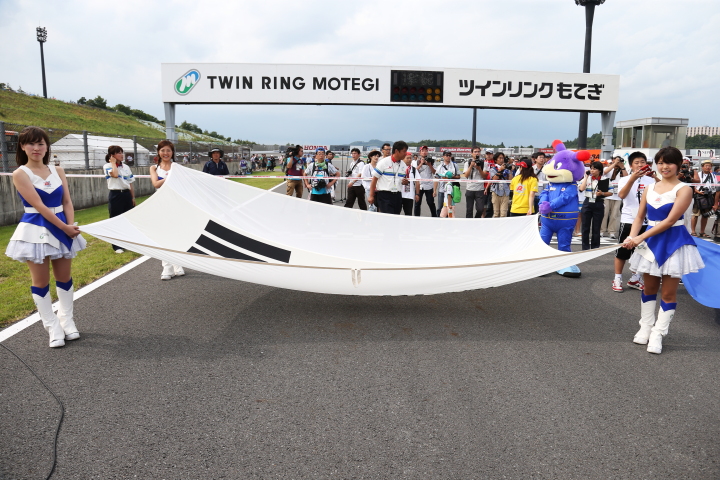 スターティンググリッド: スタート前のセレモニー。スーパーフォーミュラフラッグをもてぎエンゼルが持って行進