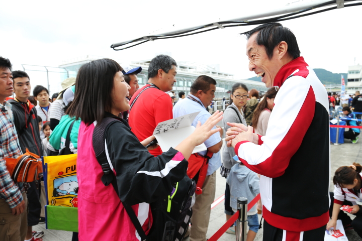 ピットウォーク: 笑顔でファンに対応するのはDOCOMO TEAM DANDELION RACINGの村岡潔監督