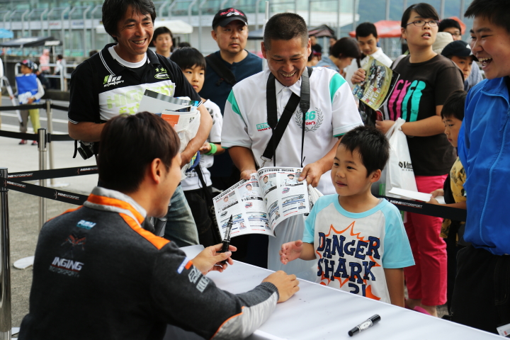 キッズピットウォーク: ファンの子供にサインをする石浦宏明（P.MU/CERUMO・INGING）