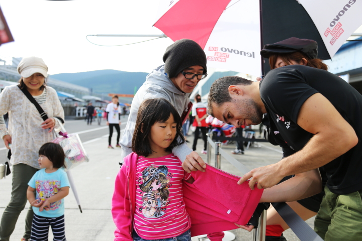 キッズピットウォーク: ファンの子供にサインをするジョアオ・パオロ・デ・オリベイラ（Lenovo TEAM IMPUL）