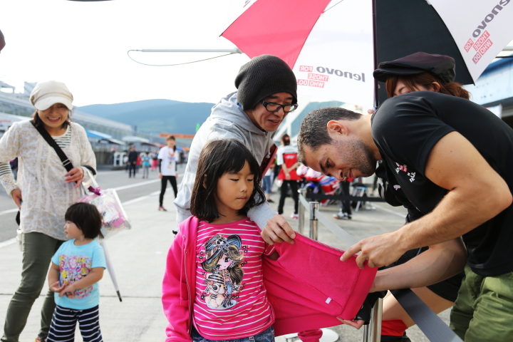 キッズピットウォーク: ファンの子供にサインをするジョアオ・パオロ・デ・オリベイラ（Lenovo TEAM IMPUL）