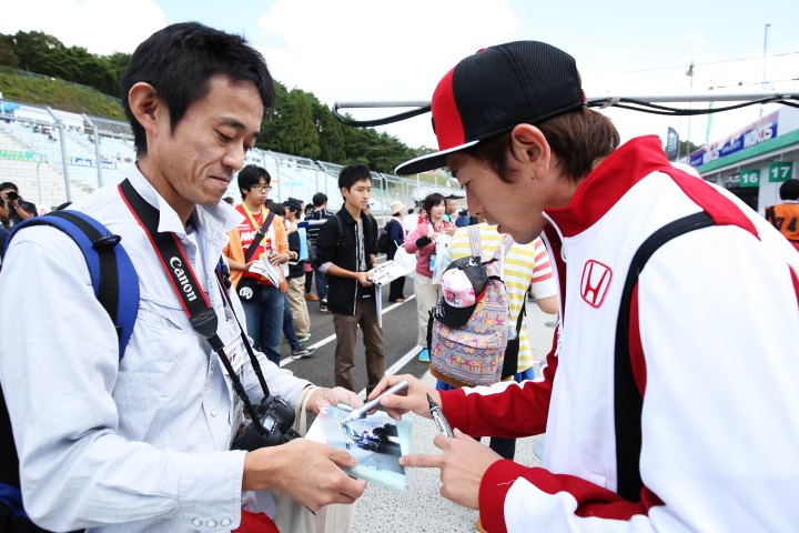 ファンにサインをする武藤英紀（DOCOMO TEAM DANDELION RACING）