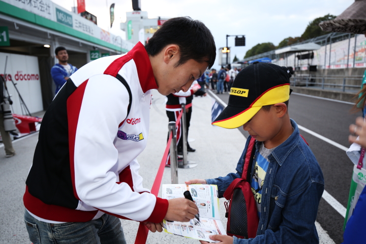 ファンの子供にサインをする野尻智紀（DOCOMO TEAM DANDELION RACING）