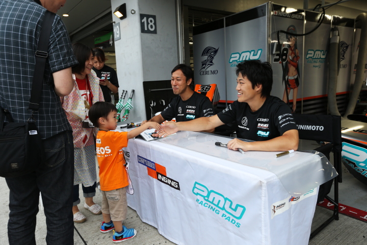キッズピットウォーク: 子供にサインをする石浦宏明（左）と国本雄資（右）（P.MU/CERUMO・INGING）