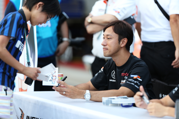 キッズピットウォーク: サインをする石浦宏明（P.MU/CERUMO・INGING）