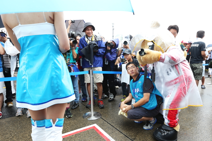 ピットウォーク: レースクイーンの写真を撮るトヨタくま吉